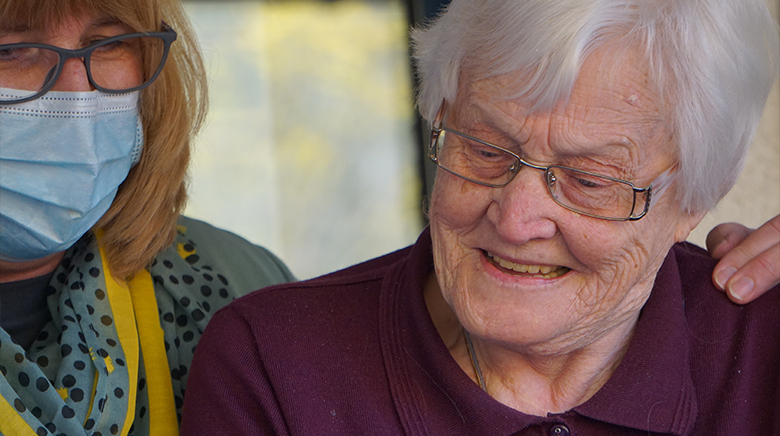 Resident and Staff Member Looking at Phone