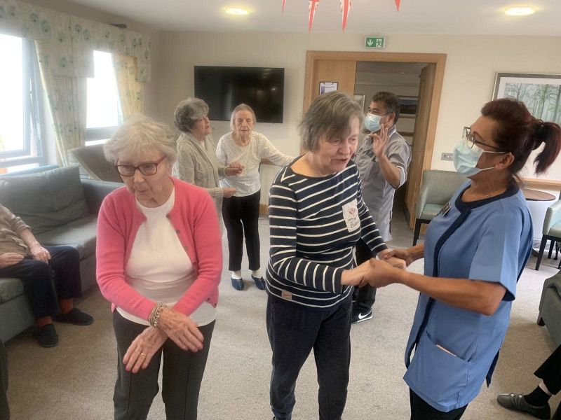 Residents Dancing In The Lounge With Staff