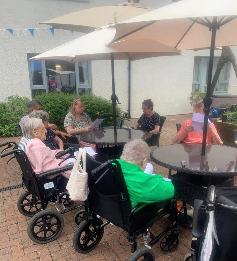 Residents Sat Around Outside Tables Enjoying August Activities